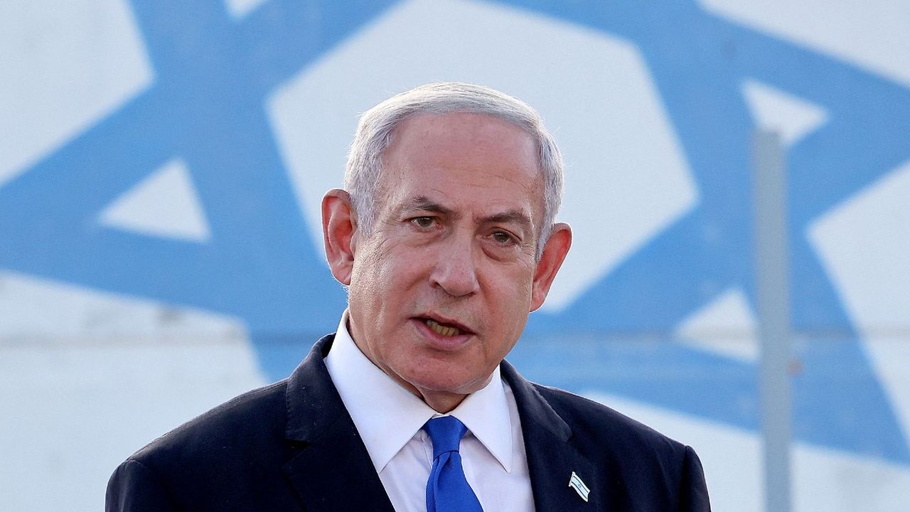 Israel&#039;s Prime Minister Benjamin Netanyahu standing in front of the Israeli flag