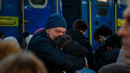 A man says goodbye to his daughter before she boards an evacuation train at Kyiv Central station