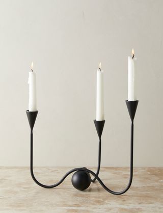 black slim candleabra with an elevated orb design