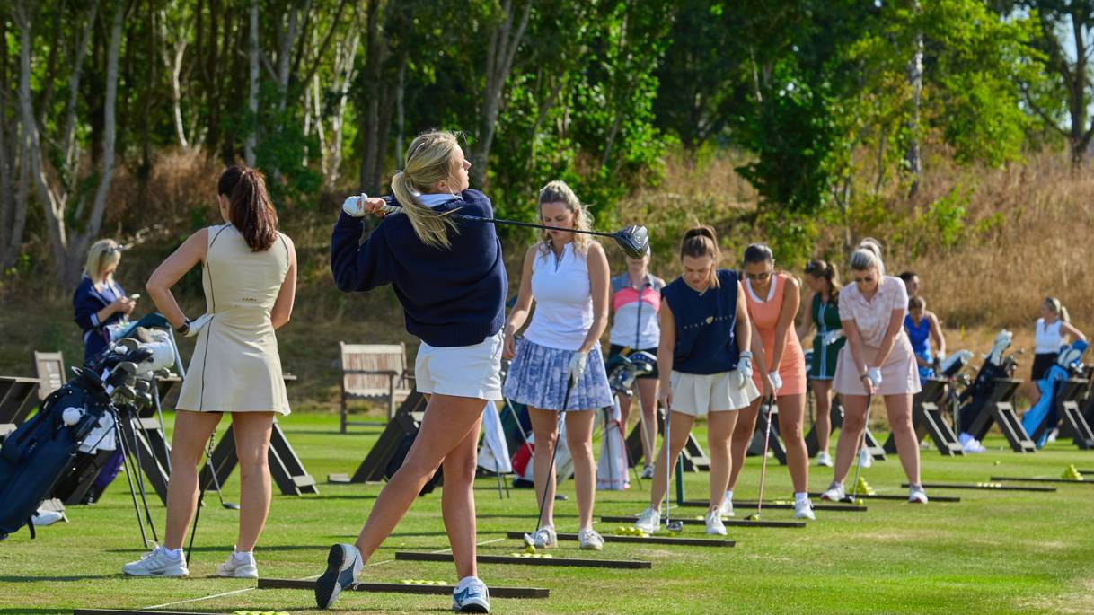 Female golfers on the driving range