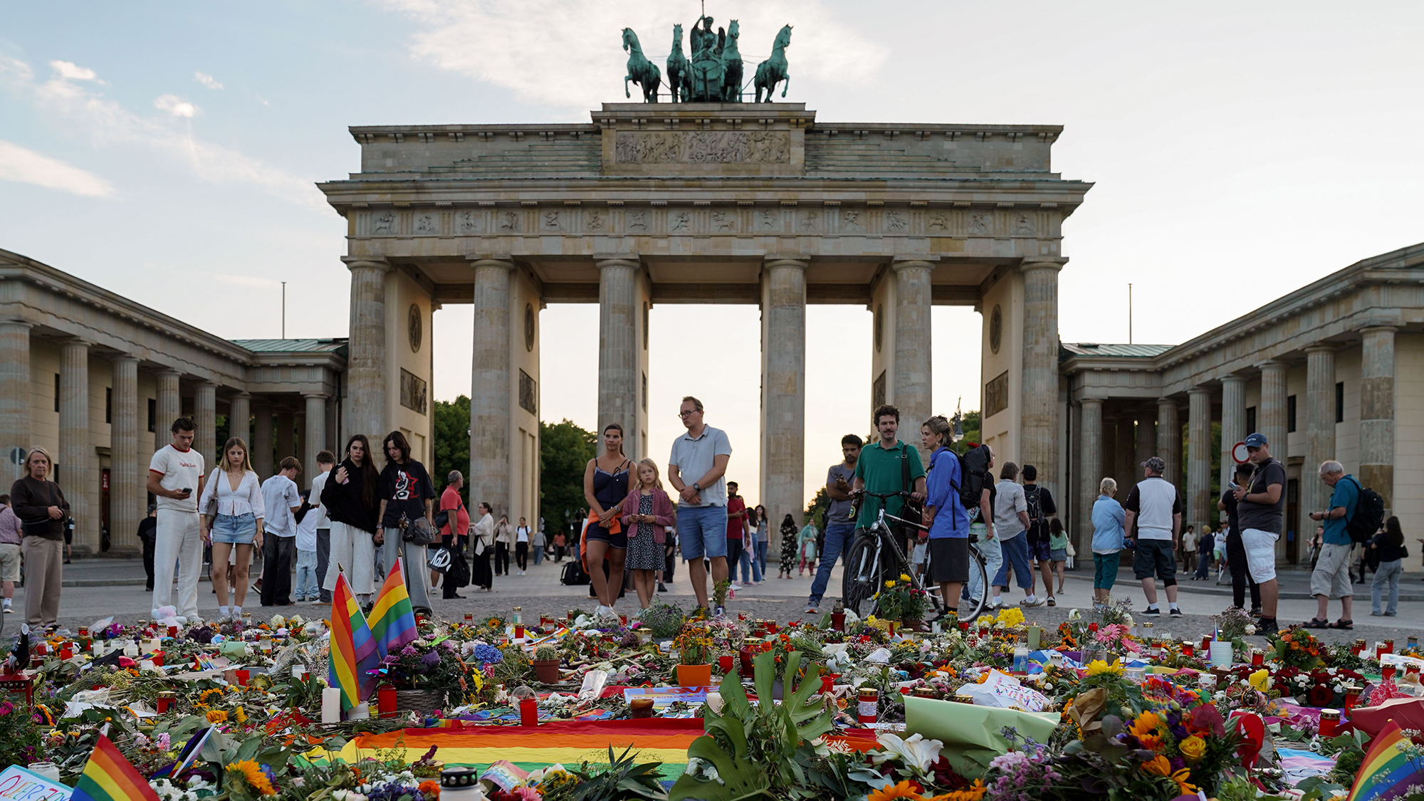People gather at a memorial in front of the Brandenburg Gate after a vehicle was driven into spectators along the route of the Christopher Street Day parade in Berlin, Germany