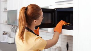 Woman cleaning a microwave