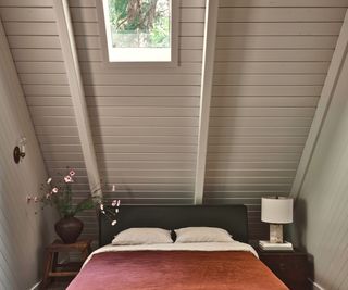 bedroom in cabin with white painted wood walls