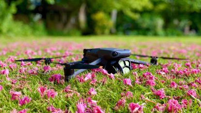 DJI Mavic 3 Pro review: pictured here, the DJI Mavic 3 Pro on a bed of flowers in a field