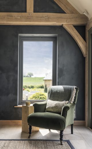 dark blue lime wash paint in oak frame living room with view through picture window