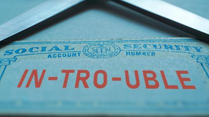 Trouble with social security concept with ID card and scissors