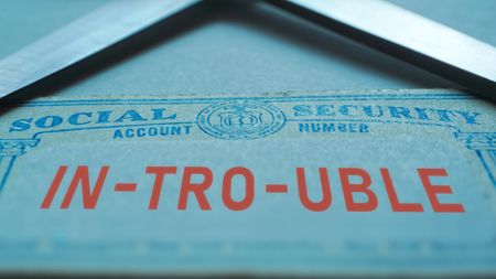 Trouble with social security concept with ID card and scissors