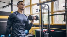 A man performing dumbbell bicep curls in the gym