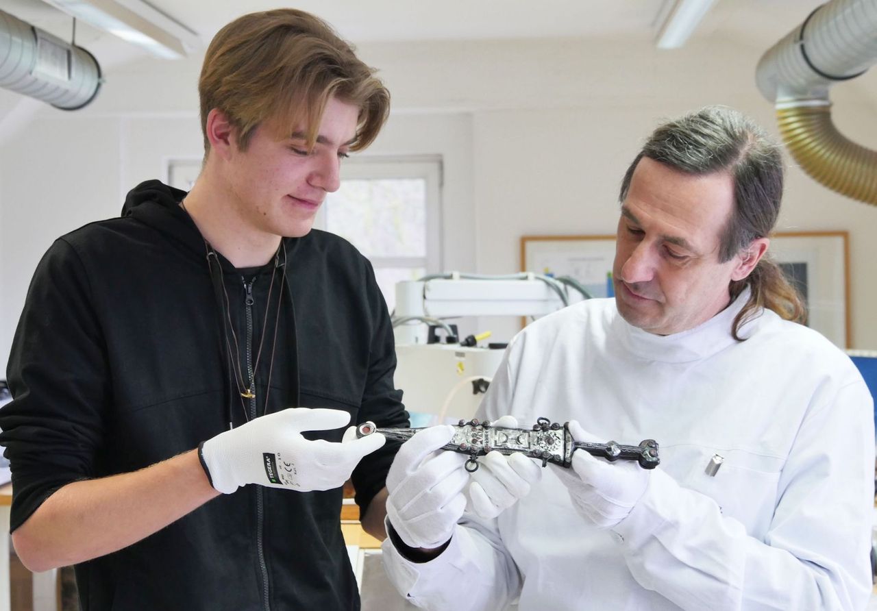 Nico Calmund and fiber restorer Eugen M&uuml;sch examine the dagger.
