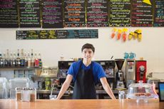 A teenager works at a coffee shop. 