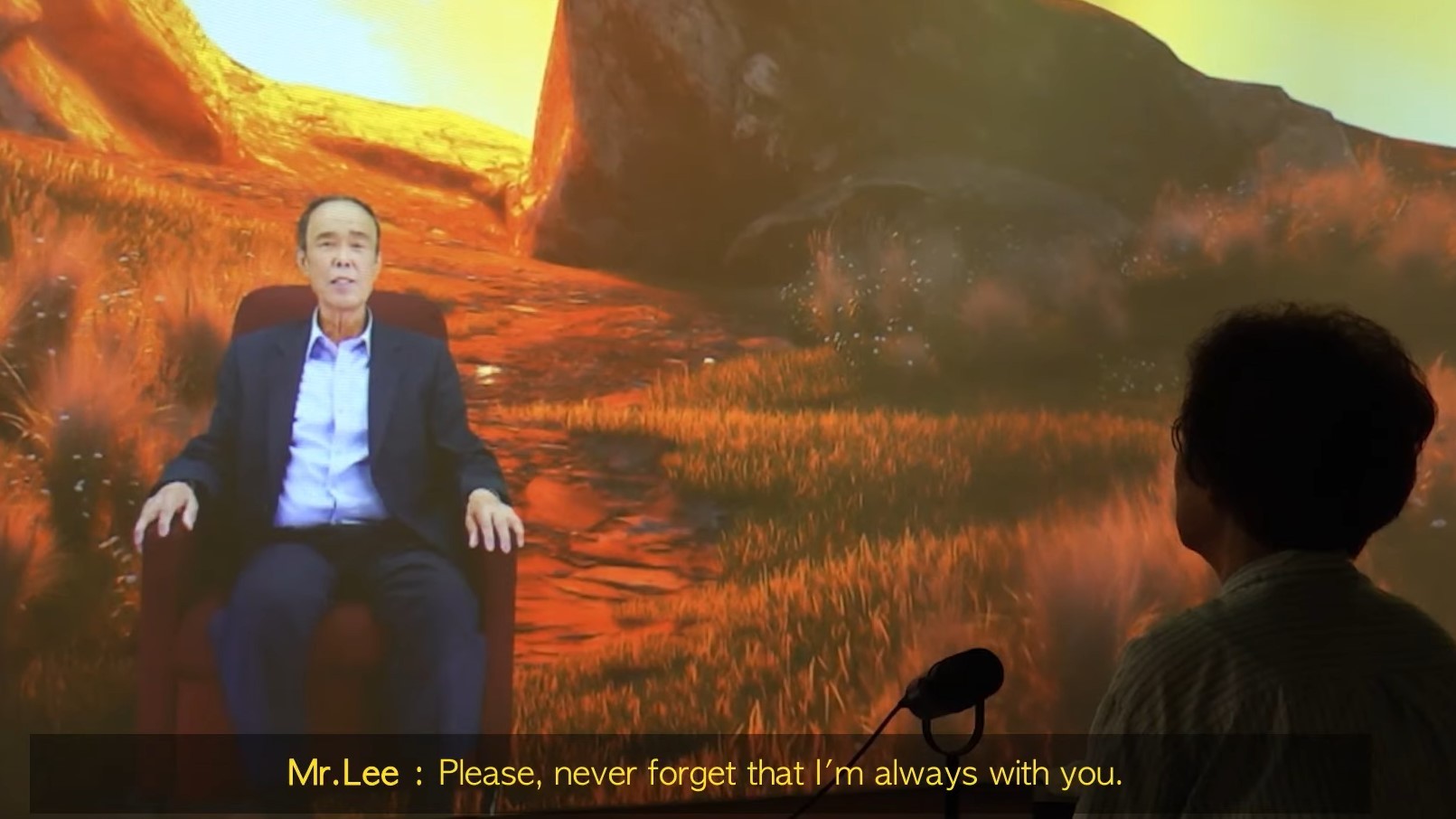 Woman in shadow talking to a virtual version of her dead husband on a screen