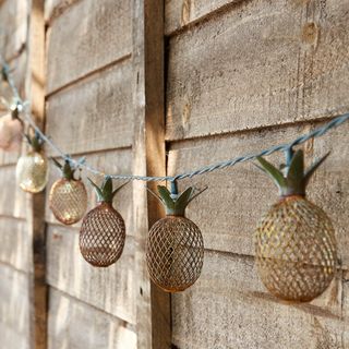 wooden wall and copper pineapple shaped lamps hanging with wires