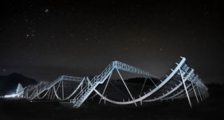 A photo shows the Canadian Hydrogen Intensity Mapping Experiment Fast Radio Burst Project at night.