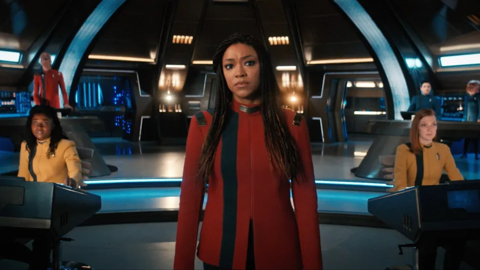 Commander Saru (Doug Jones), Lieutenant Joann Owosekun (Oyin Oladejo), Captain Michael Burnham (Sonequa Martin-Green), Lieutenant Keyla Detmer (Emily Coutts), and two unidentified Starfleet officers on the bridge of the U.S.S. Discovery from Star Trek: Discovery