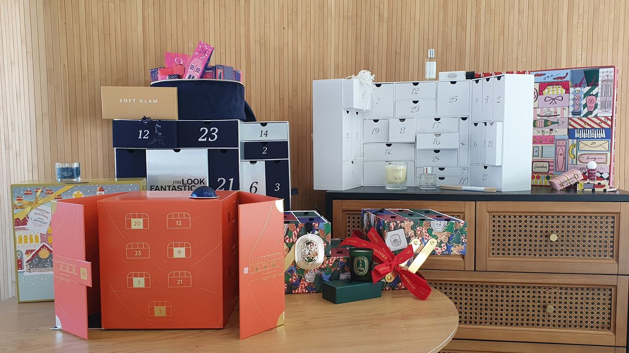 Six advent calendars set against a wood-panelled background