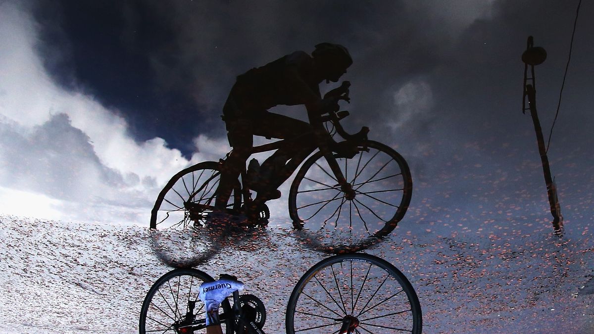 GLASGOW, SCOTLAND - AUGUST 03: A cyclist rides through a puddle during the Men&#039;s Cycling Road Race during day eleven of the Glasgow 2014 Commonwealth Games on August 3, 2014 in Glasgow, United Kingdom. (Photo by Ryan Pierse/Getty Images)