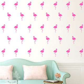 Room with blue couch and flamingo wallpaper