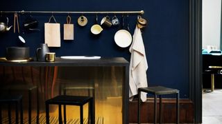 Navy blue kitchen with brass surfaces and accessories to consider how to clean brass properly