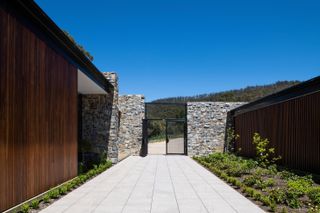The entrance courtyard, with the utility spaces to the right at Tinderbox House, a Tasmania retreat by Studio Ilk Architecture