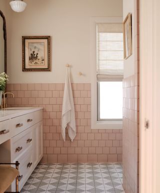 Small bathroom with pink walls, pink wall times and patterned floor tiles