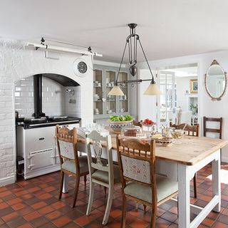 kitchen area with white wall and dining table and chairs