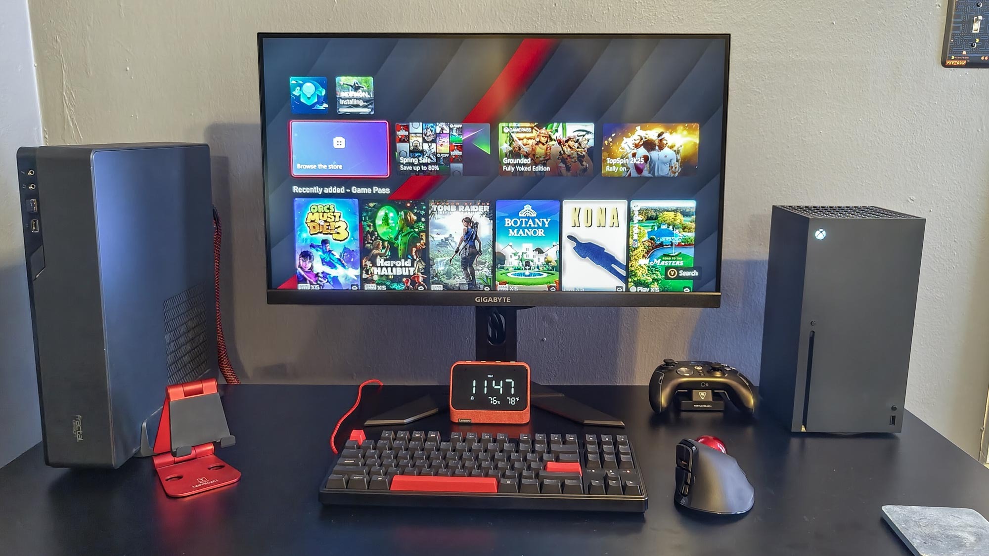 An Xbox Series X on a desk next to a PC