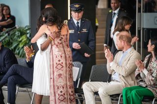 Meghan Markle hugs the vice president of colombia in a johanna ortiz dress