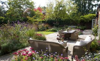 seating area and outdoor table on patio in traditional country garden