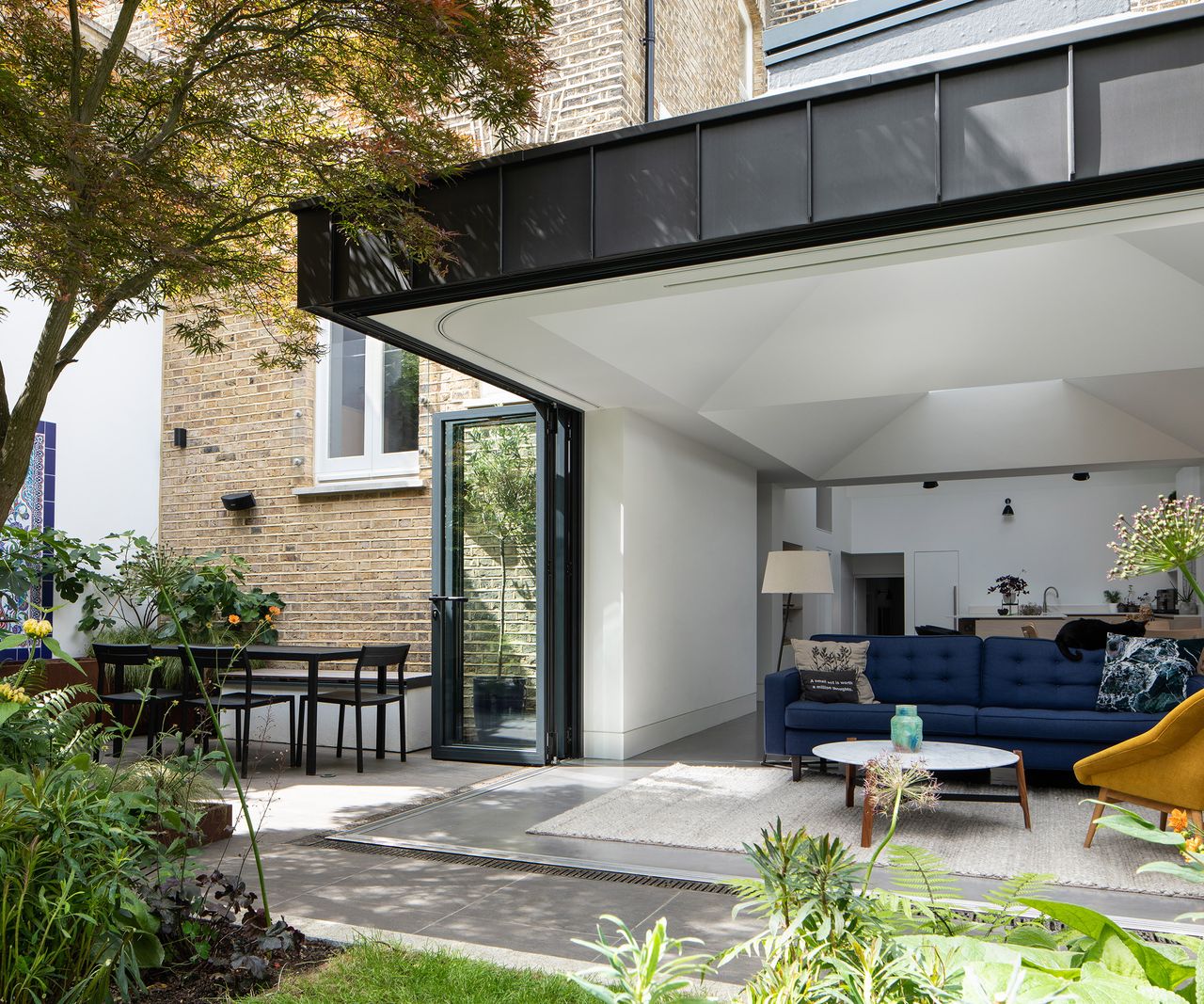 Cantilevered wall in a ground floor kitchen extension with bifold doors that fully open along both walls