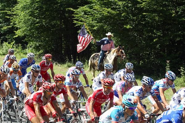 A fan of the Tour's American riders follows the peloton on horseback.