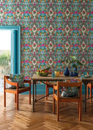 wooden dining room table and chairs and floral and fruit wallpaper