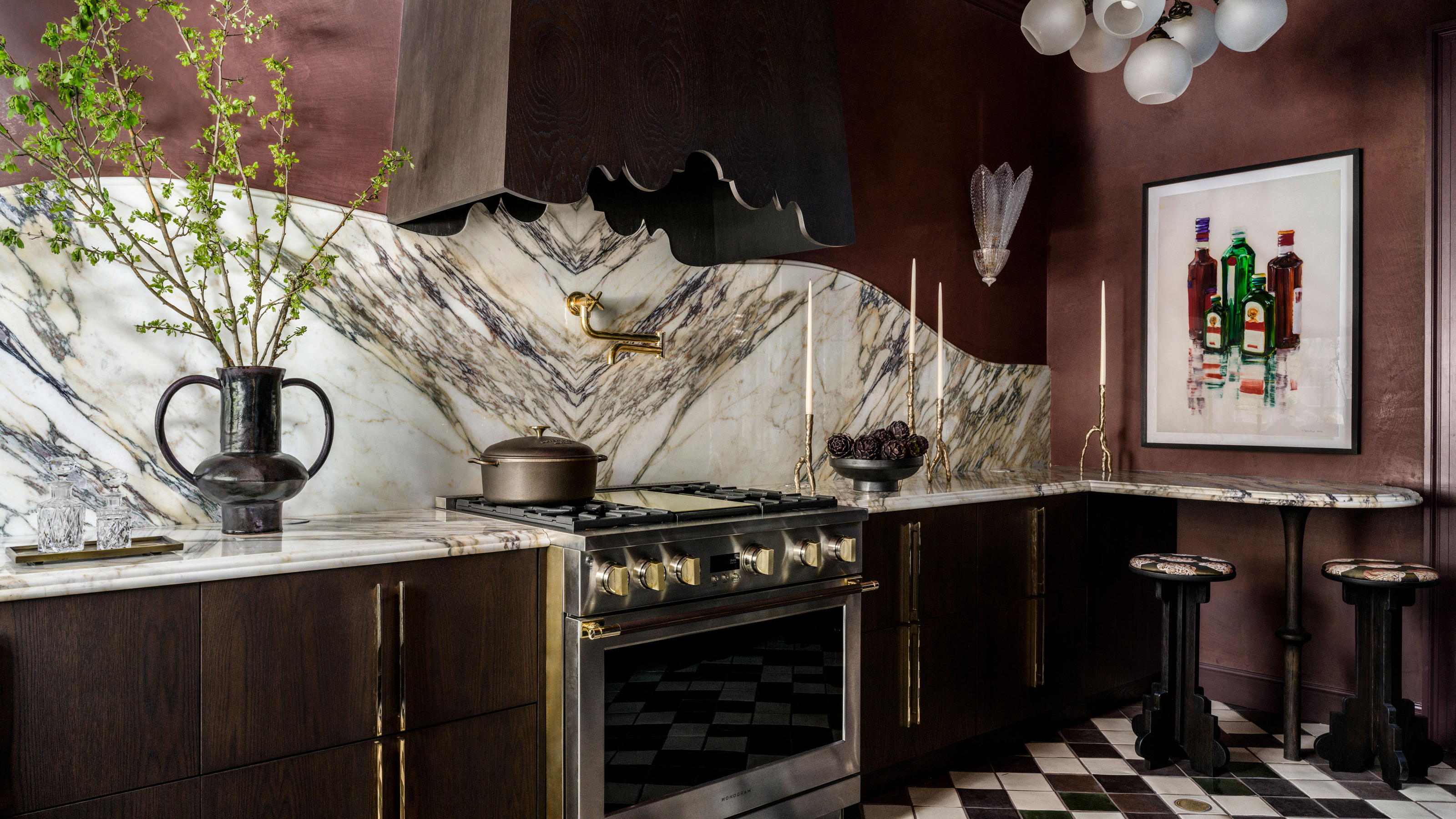 a burgundy red kitchen with a marble backsplash