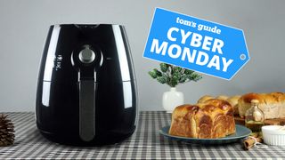 An air fryer sitting on a table next to some bread and oil
