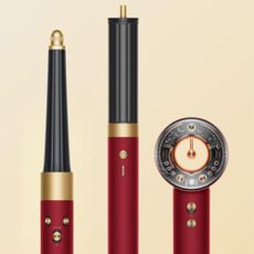 Dyson Airwrap in red and gold with beige background