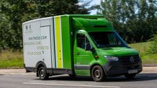 A Waitrose delivery van driving on a road