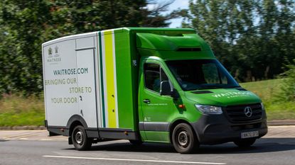 A Waitrose delivery van driving on a road