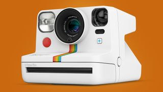 The Polaroid Now+ instant camera on an orange background