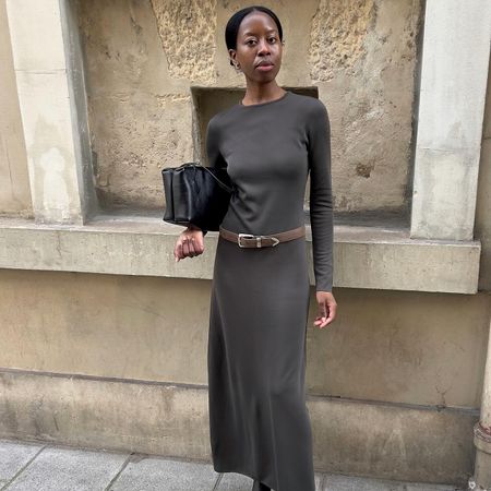 Woman wears a long sleeve maxi dress, pointy heeled ankle boots and a brown Western-style belt