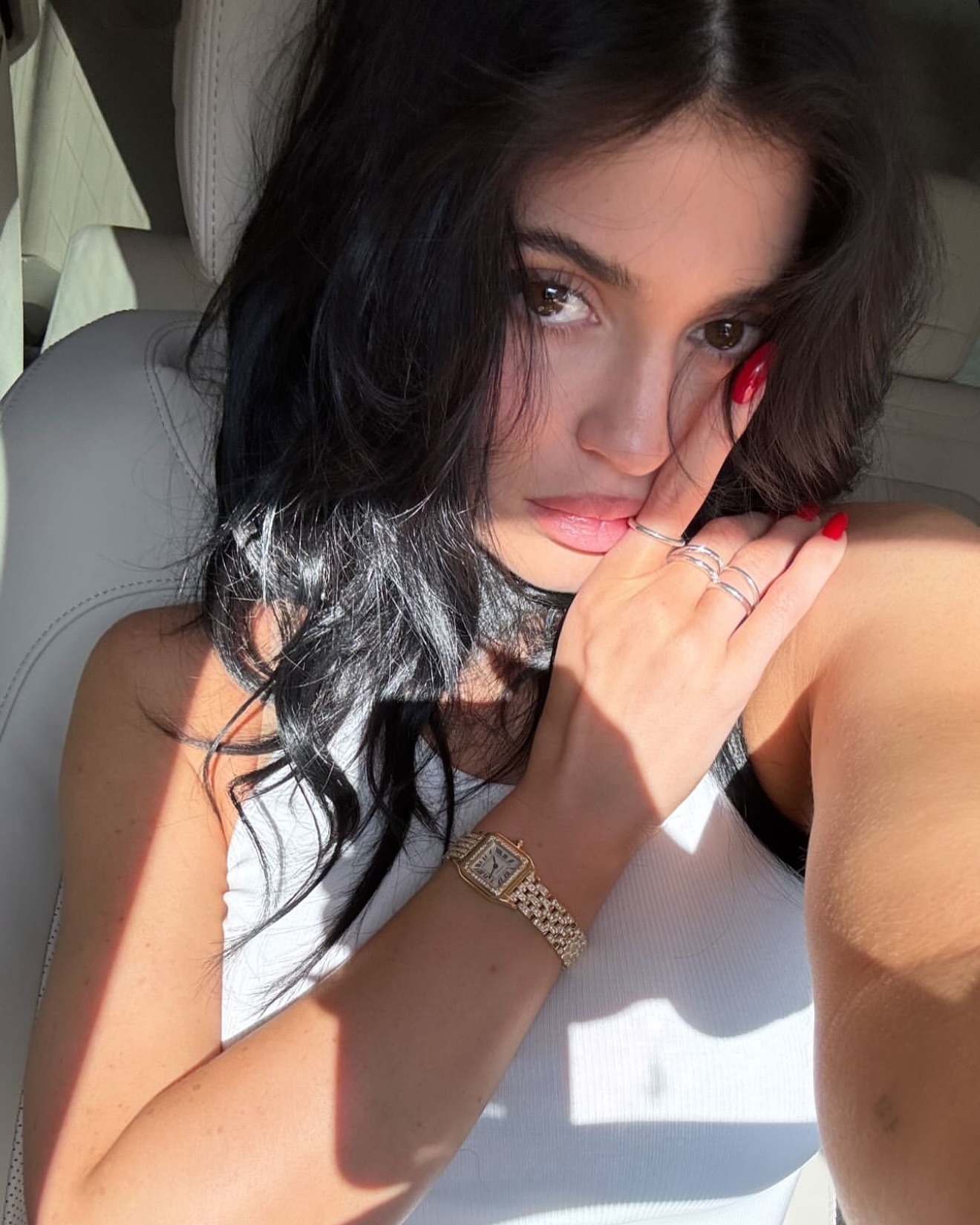 Kylie Jenner taking a selfie with a bright red manicure