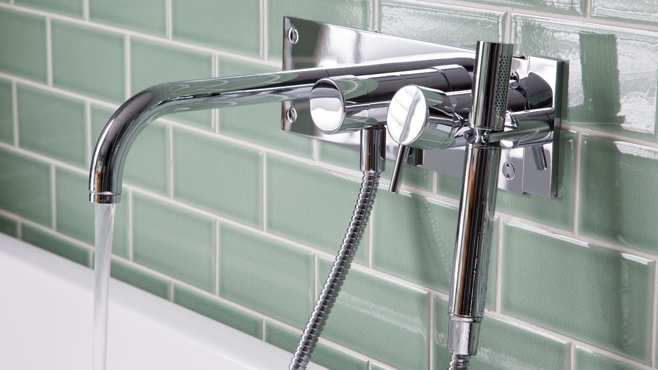 Blue tiles with silver tap over bathtub 