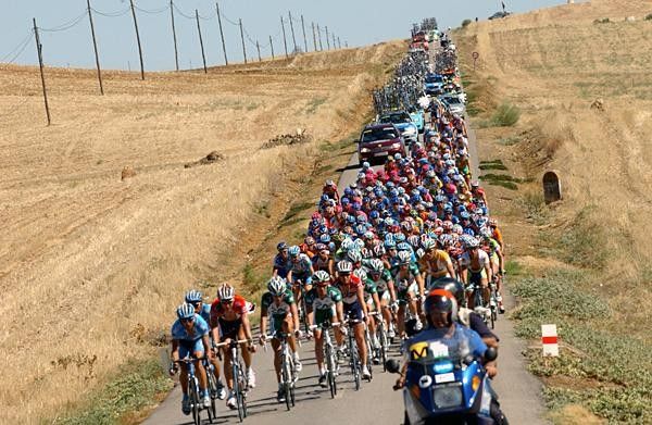 The peloton rides down another narrow back road