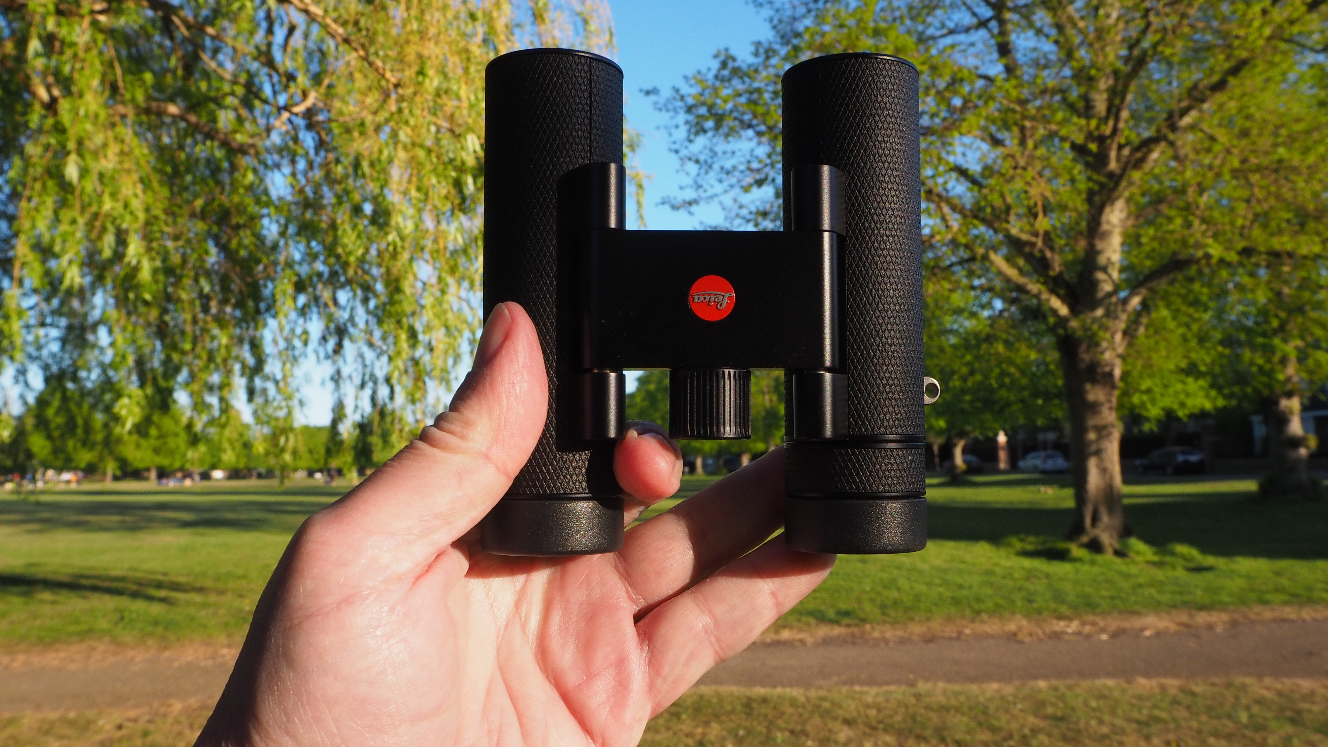 Leica Noctivid Compact 10x25 binoculars in a person's hand