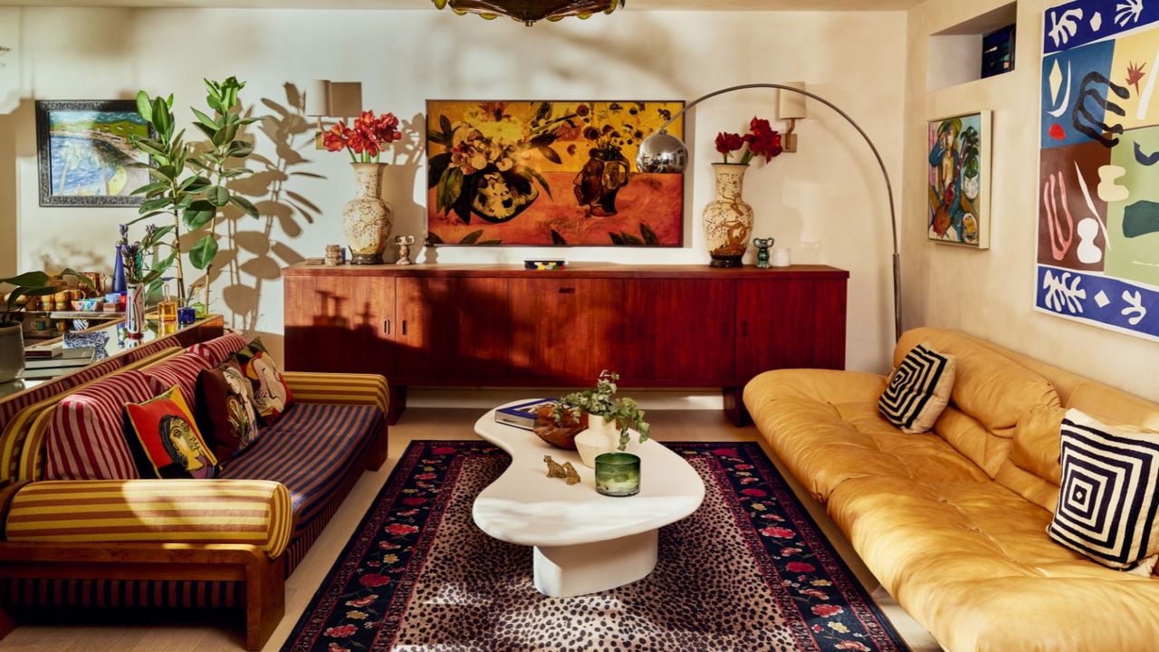 neutral modern earthy living room with a large mid century credenza, 70s style low couch, white coffee table, and a leopard print rug from the rixo x ruggable collection