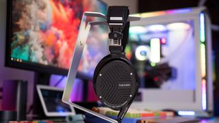 Thieaudio Wraith on V-Moda stand with a gaming rig in the background