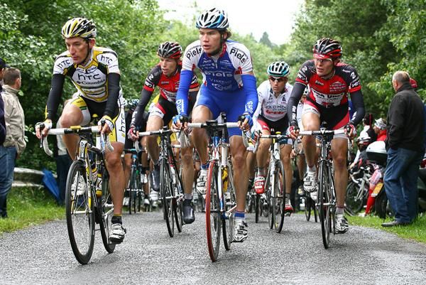 The bunch crest the top of a climb