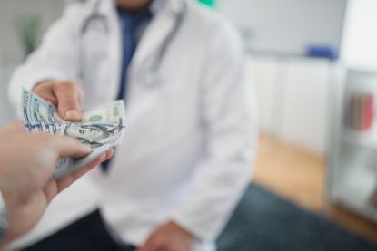 A person paying a doctor
