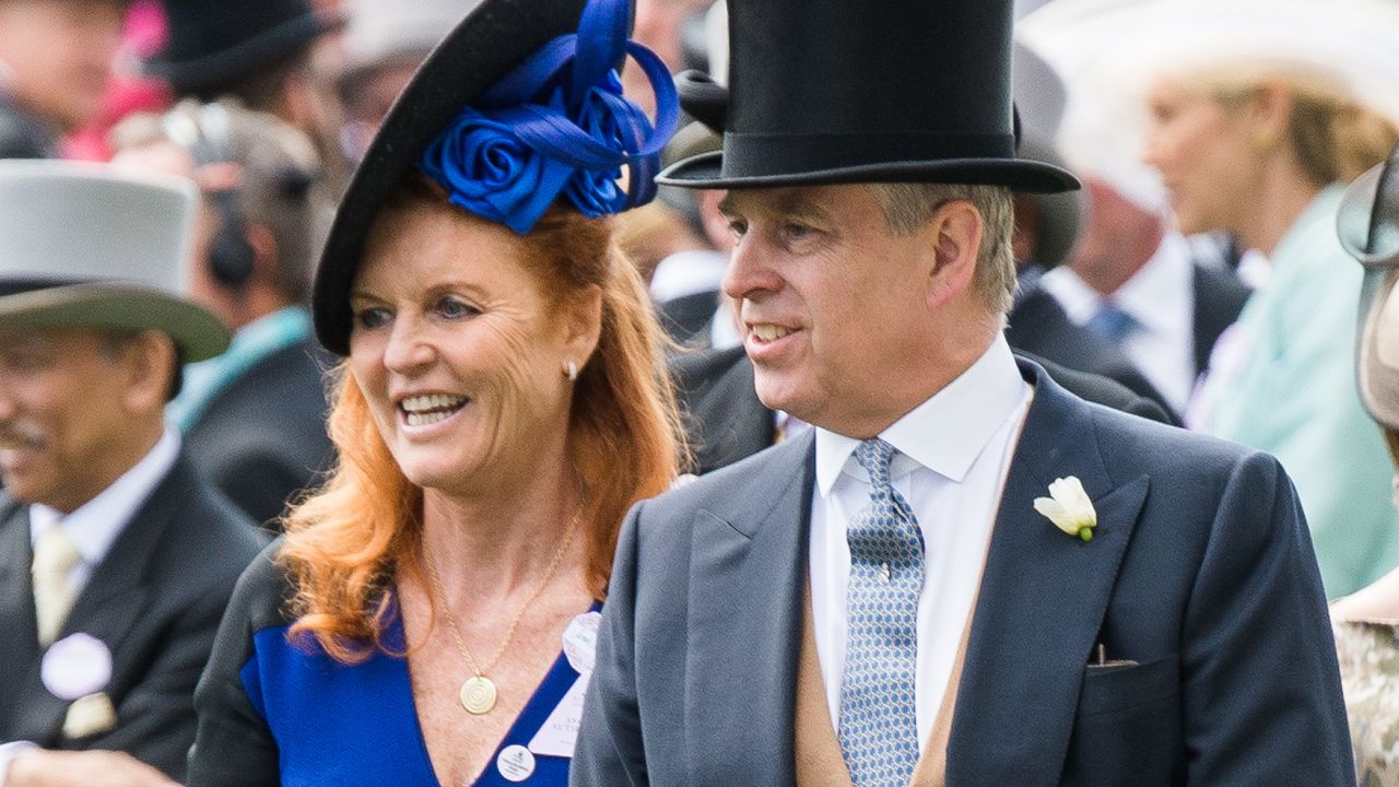 Sarah Ferguson wears a blue dress and matching hat as she attends Acot with Prince Andrew who is wearing a top hat and tails