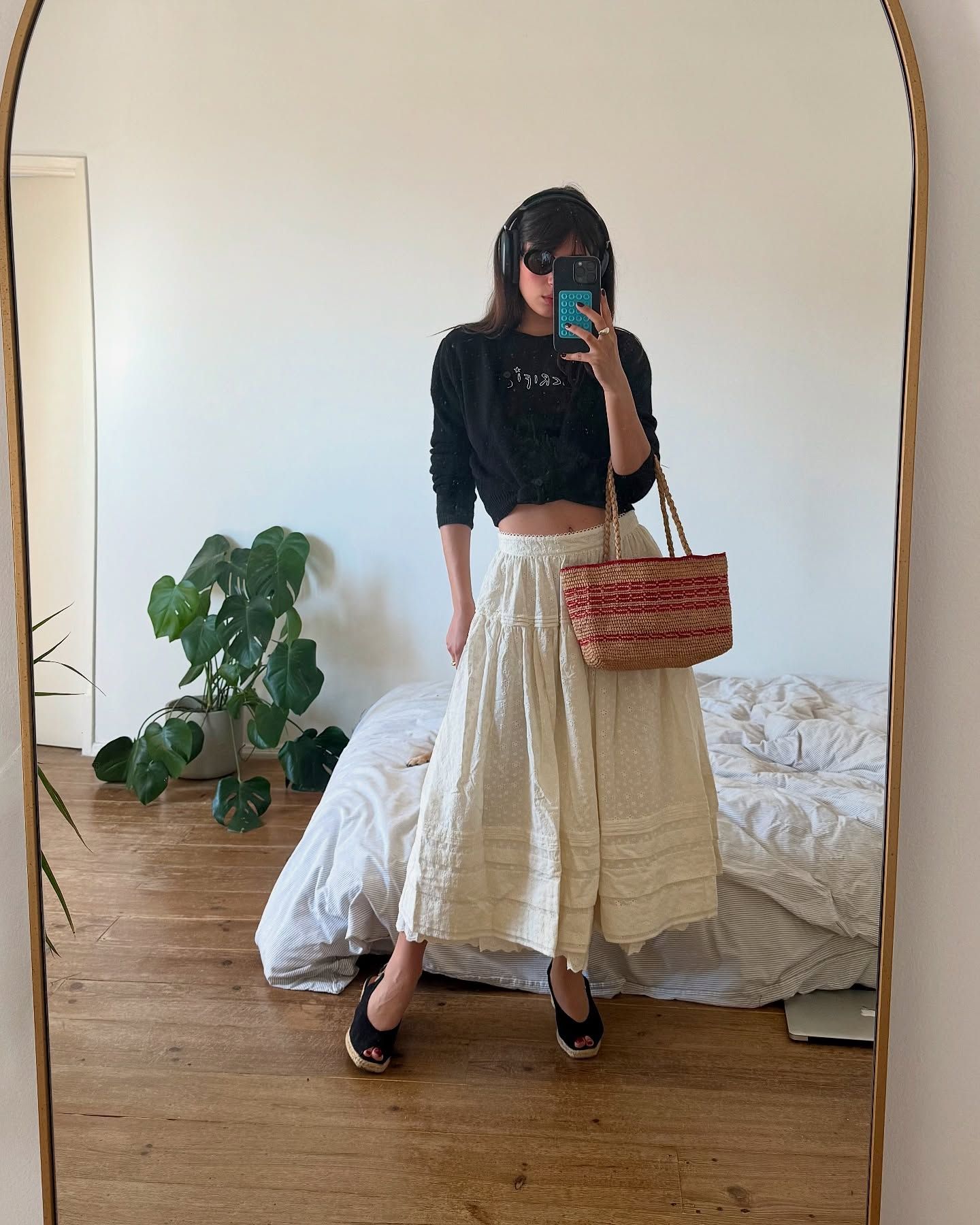 Woman in sweater, white skirt, and espadrilles