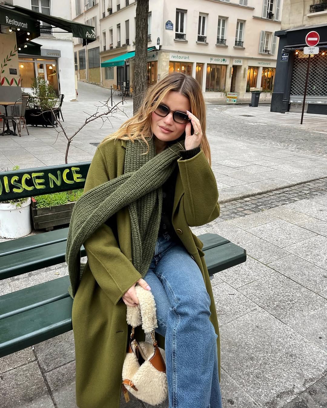 Sabina in a green coat and scarf