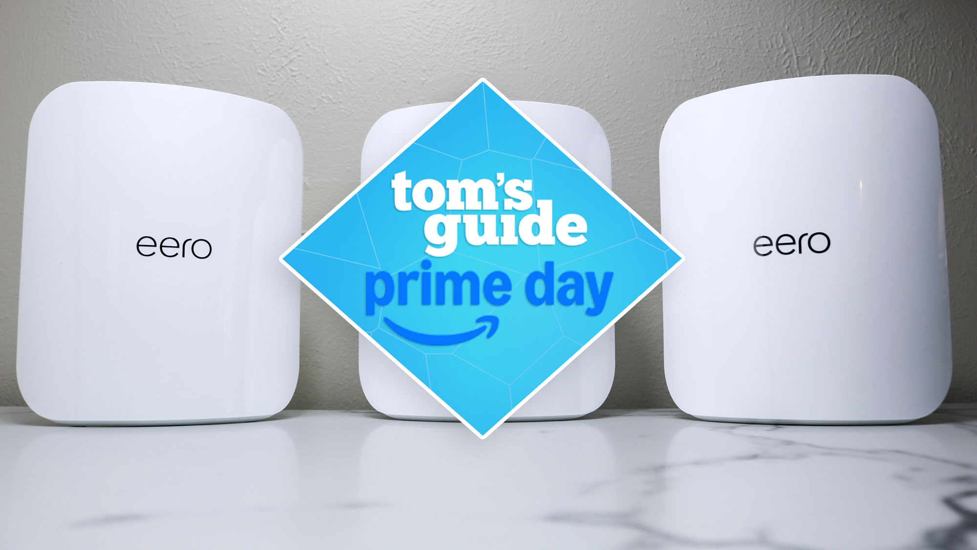 Three eero Max 7 mesh routers on a desk with a Tom's Guide Prime Day deals badge in the middle